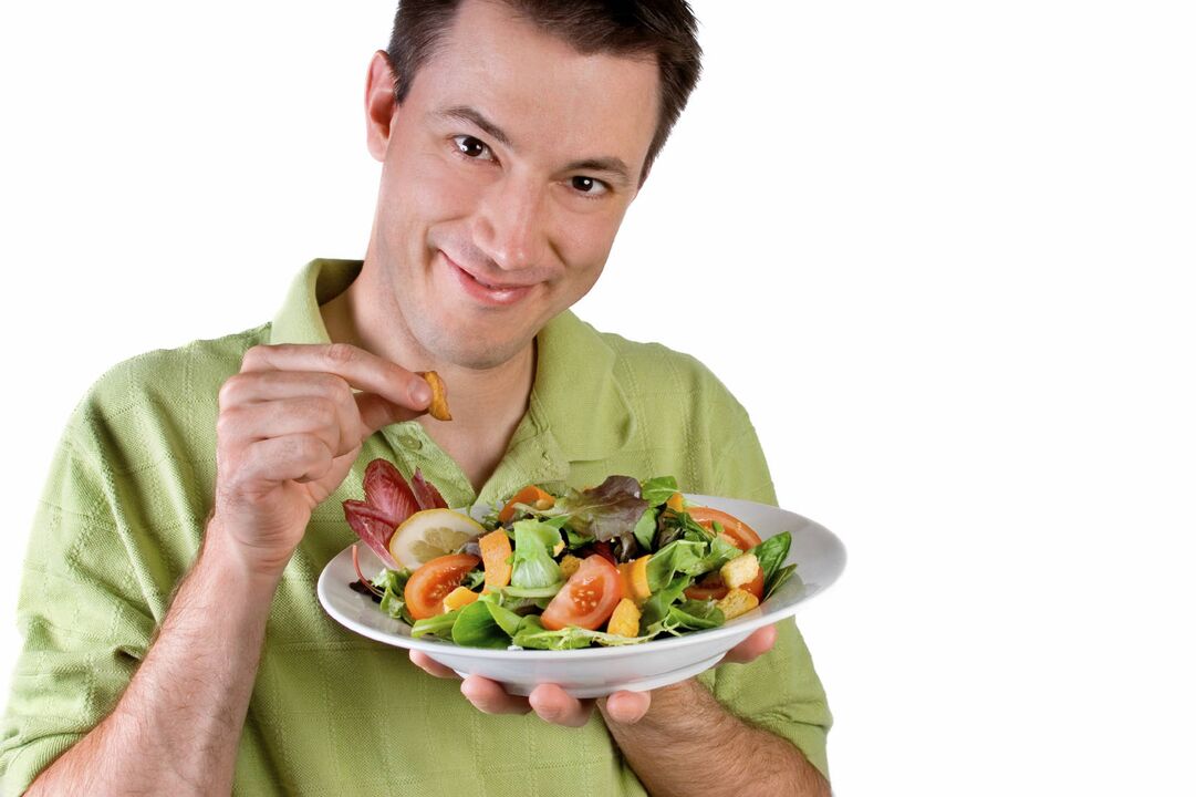 mannen äter grönsaksallad för styrka